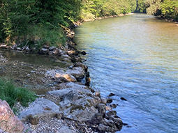 Steine blockieren die Mündung des Baches in den Fluß