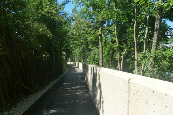 Der Radweg in der Saliterau führt entlang der neuen Hochwasserschutz-Mauer an der Alz. Mauer entlang des Radweges