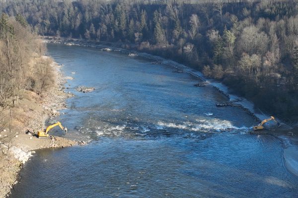 Mitten im Fluss: Zwei Bagger errichten Stützschwellen für das offene Deckwerk in der Salzach Mitten im Fluss: Zwei Bagger errichten Stützschwellen für das offene Deckwerk in der Salzach.