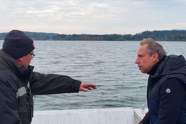 Unterwegs auf dem Chiemsee: Staatsminister Thorsten Glauber im Gespräch mit Bootsfahrer Horst Jackel. Staatsminister Thorsten Glauber im Gespräch mit Bootsfahrer Horst Jackel, unterwegs auf dem Chiemseee.